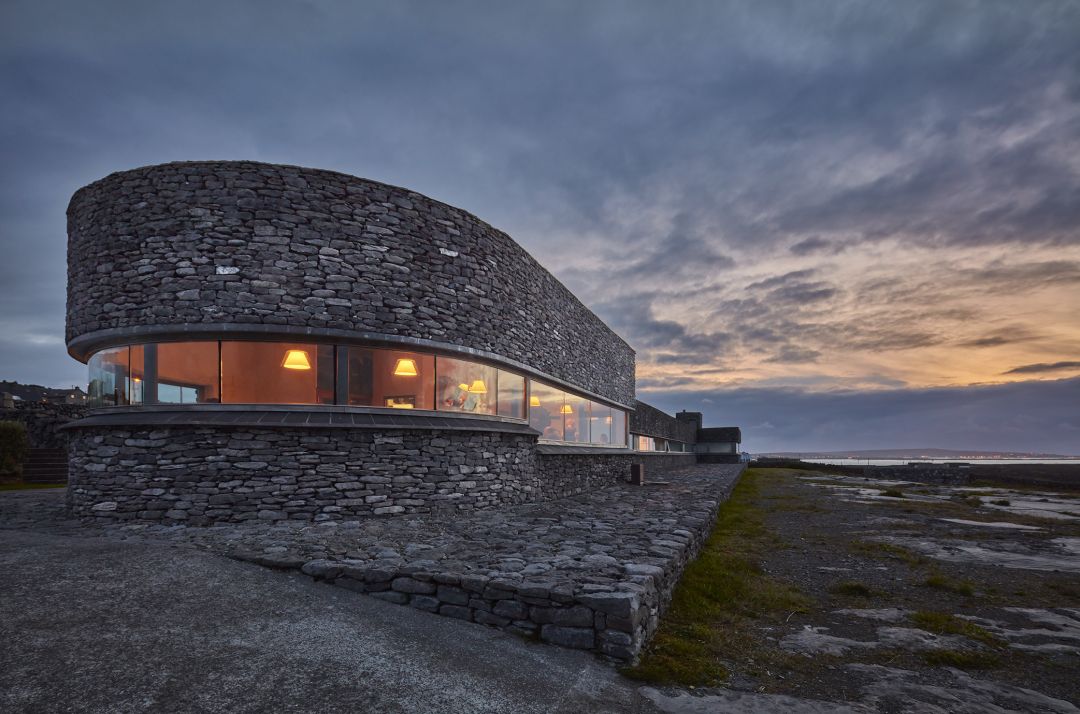 Inis Meain Holiday home built in local stone, half rounded architecture design against sun down lit sky in Ireland | Raw Heritage Retreats: Design-Led Hideaways & Nature Sanctuaries Across Europe