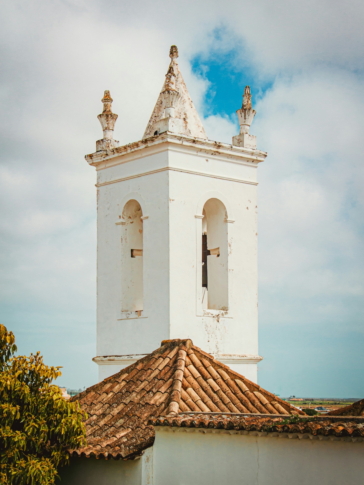 White Traditional Church Tower against blue cloudy skies |Ria Formosa to Ilha de Tavira – Nature, Culture & Design in the Algarve