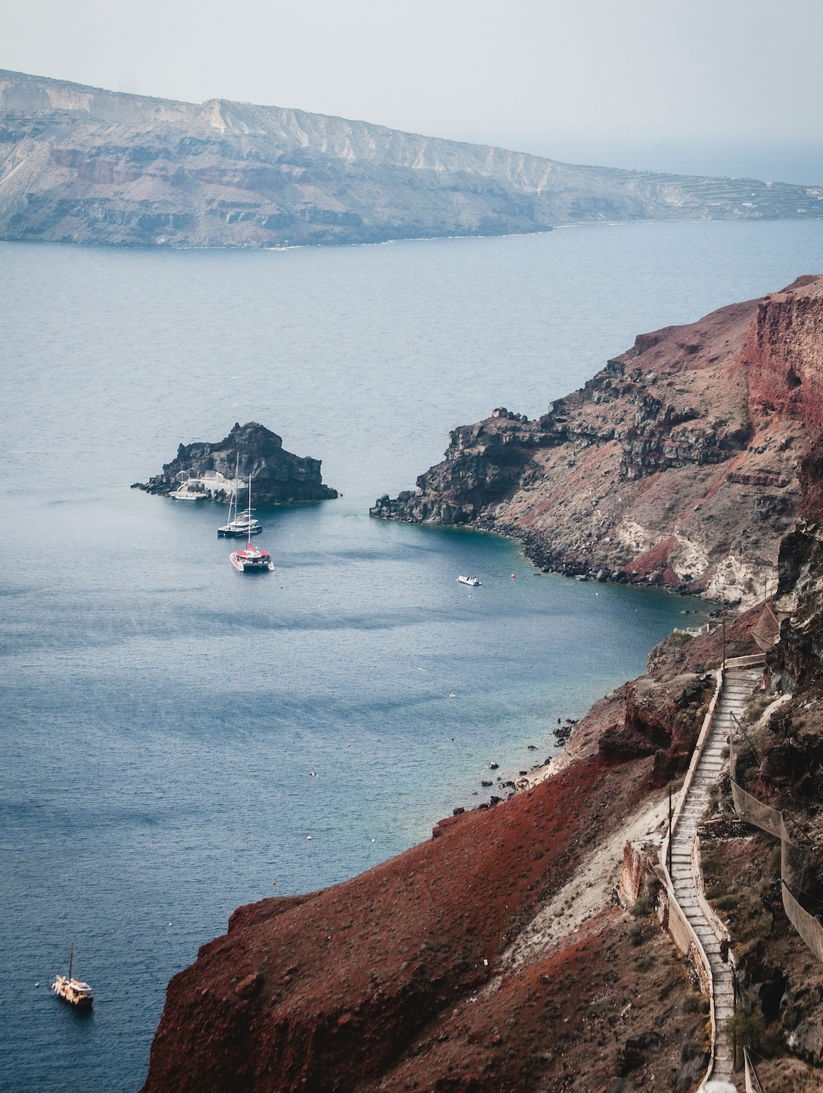 Crescent blue Aegean Sea framed by the black sands | Santorini Noir: Volcanic Beauty, Architecture and Cycladic Soul | The Cyclades Island of Greece | The Aficionados 