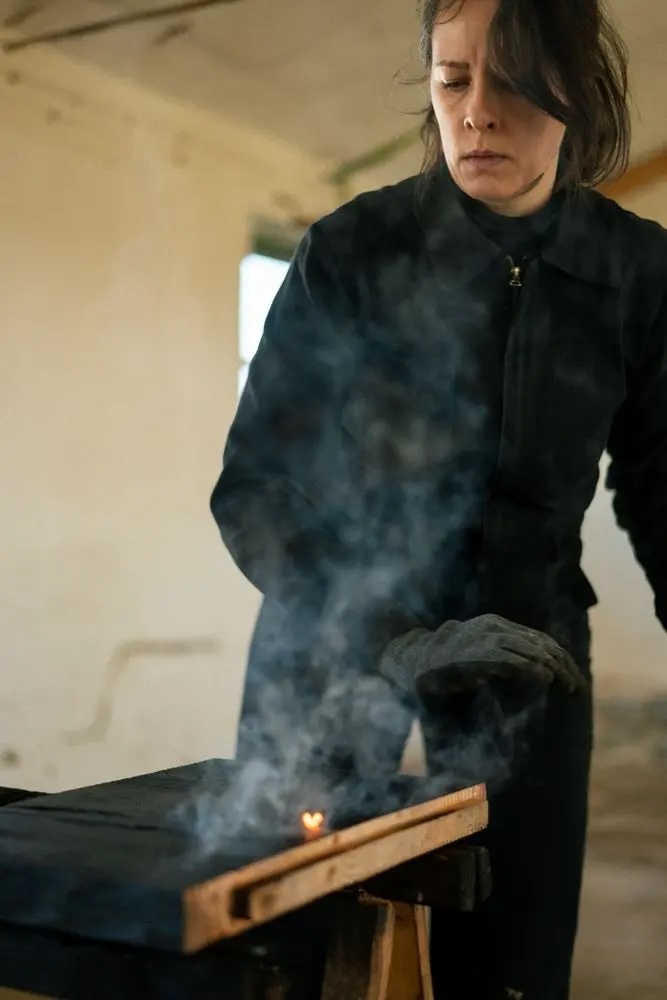Artisan burning wood surface by hand, craft process at Lisbon Design Week 2026