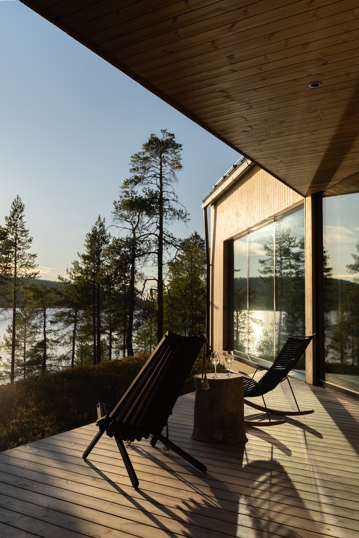 beneath a pitched timber ceiling with gable glazing onto the lake and pines | Inai Haven, Lake Inari, Lapland, Finland | The Aficionados