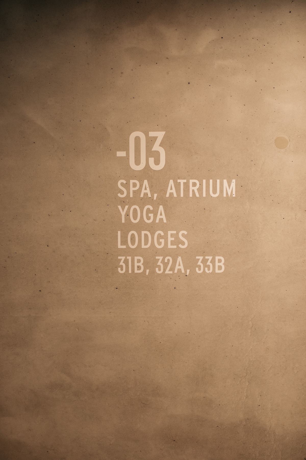 Stencil writing on the wall to indicate Spa, changing rooms etc within a hotel wellness. White font n a natural teracotta wall |Stone, Steam and Stillness: Inside the Spa Sanctuary at Maistra 160