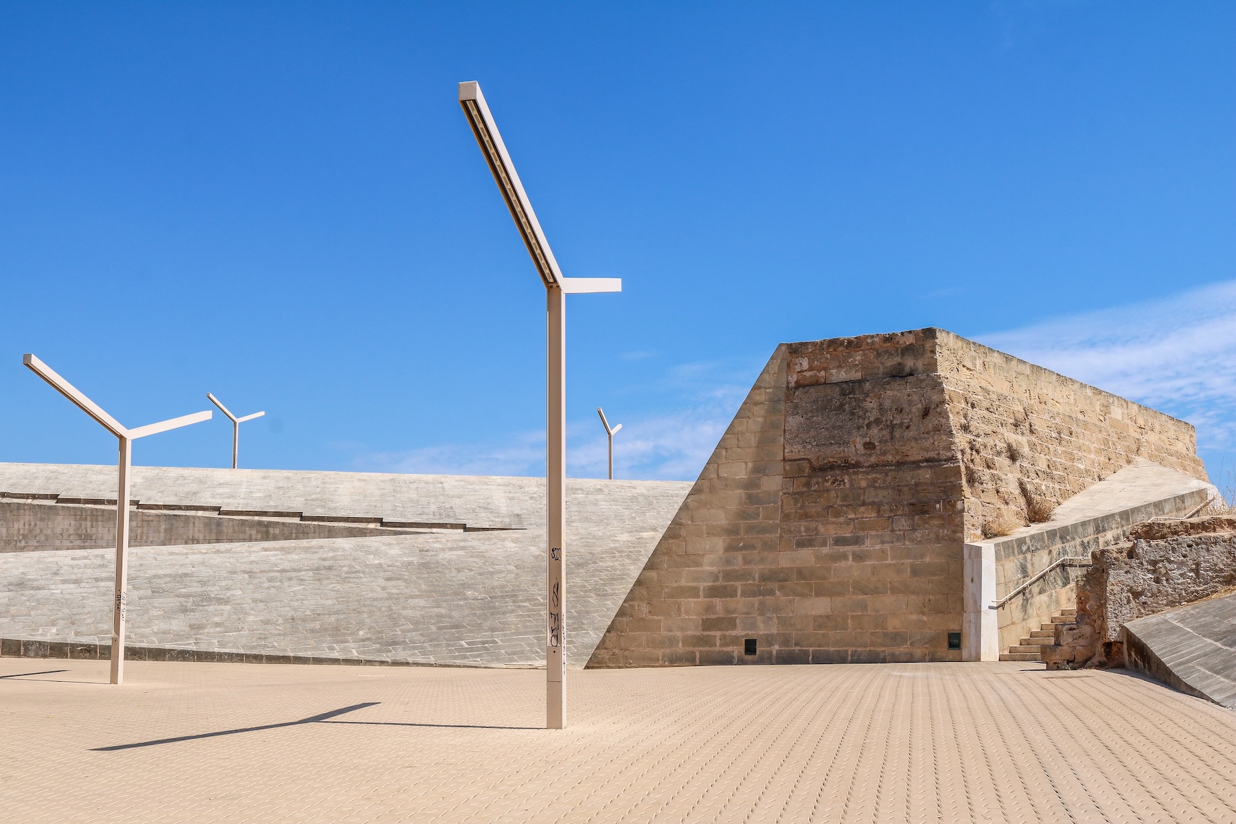 The angled sandstone prow of the bastion of Sant Pere meeting the pale concrete of the modern rampart walk | The Aficionados