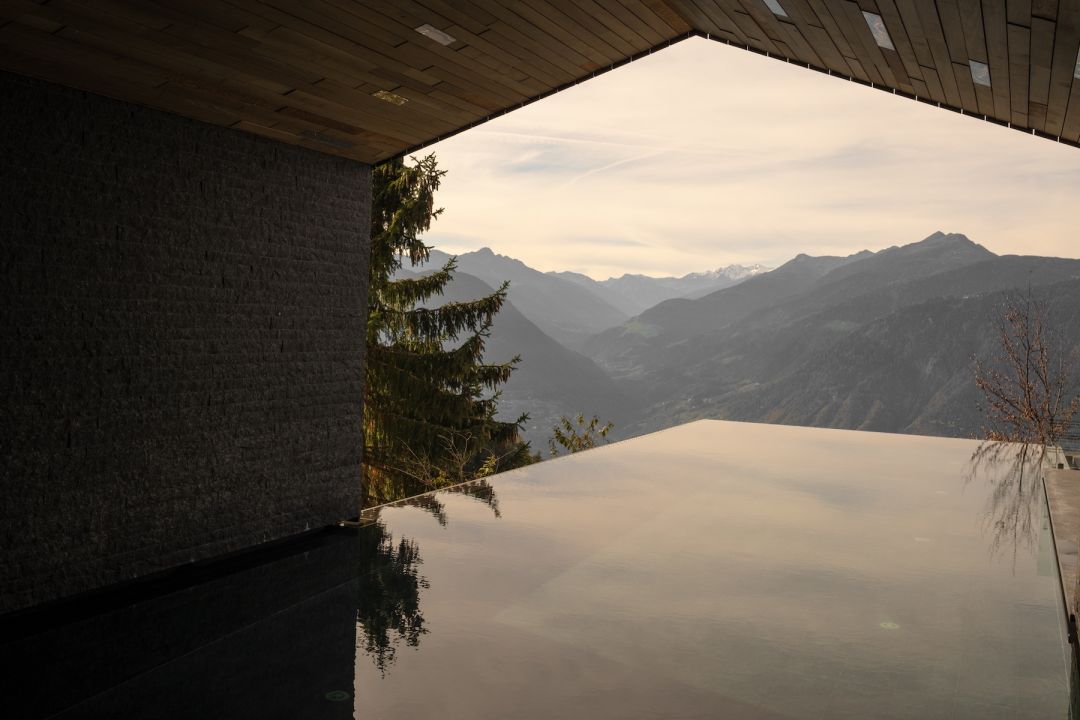 View form the infinity poool across the mountains Alps, as sun sets, Architectural feature of the swimming pool 