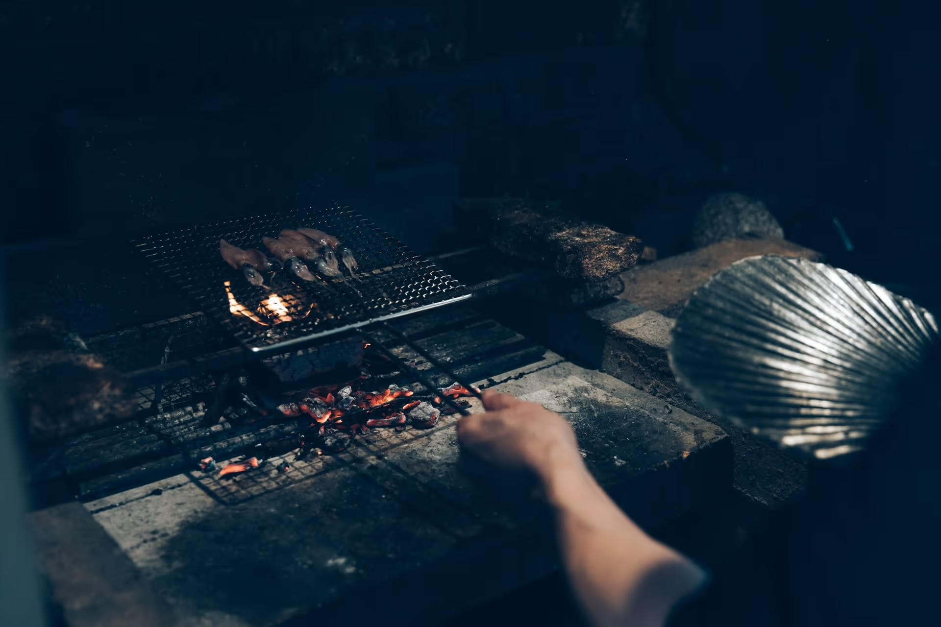 Small squid grilling over charcoal on the brick hearth at Auberge Né, Shibata | The Aficionados