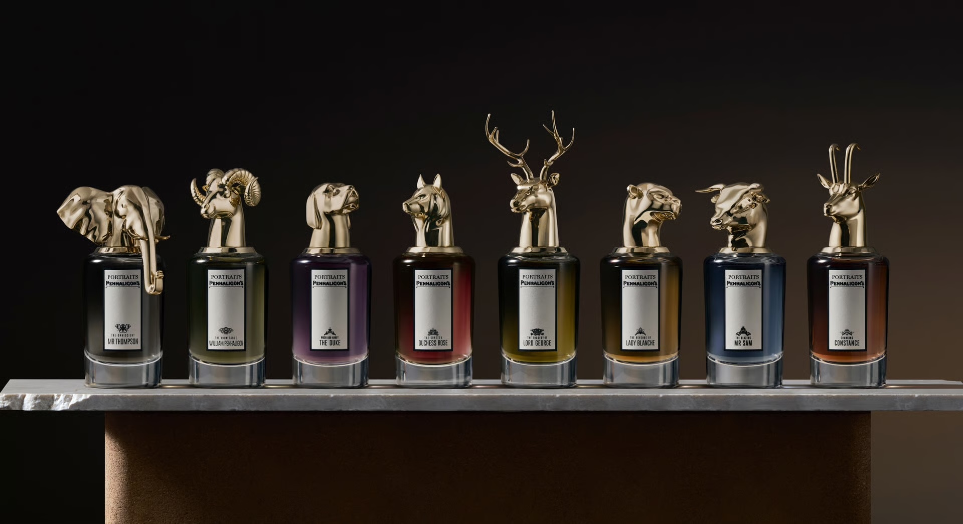 Penhaligon's Portraits collection: a row of fragrance bottles topped with gold animal-head caps including an elephant, ram and stag