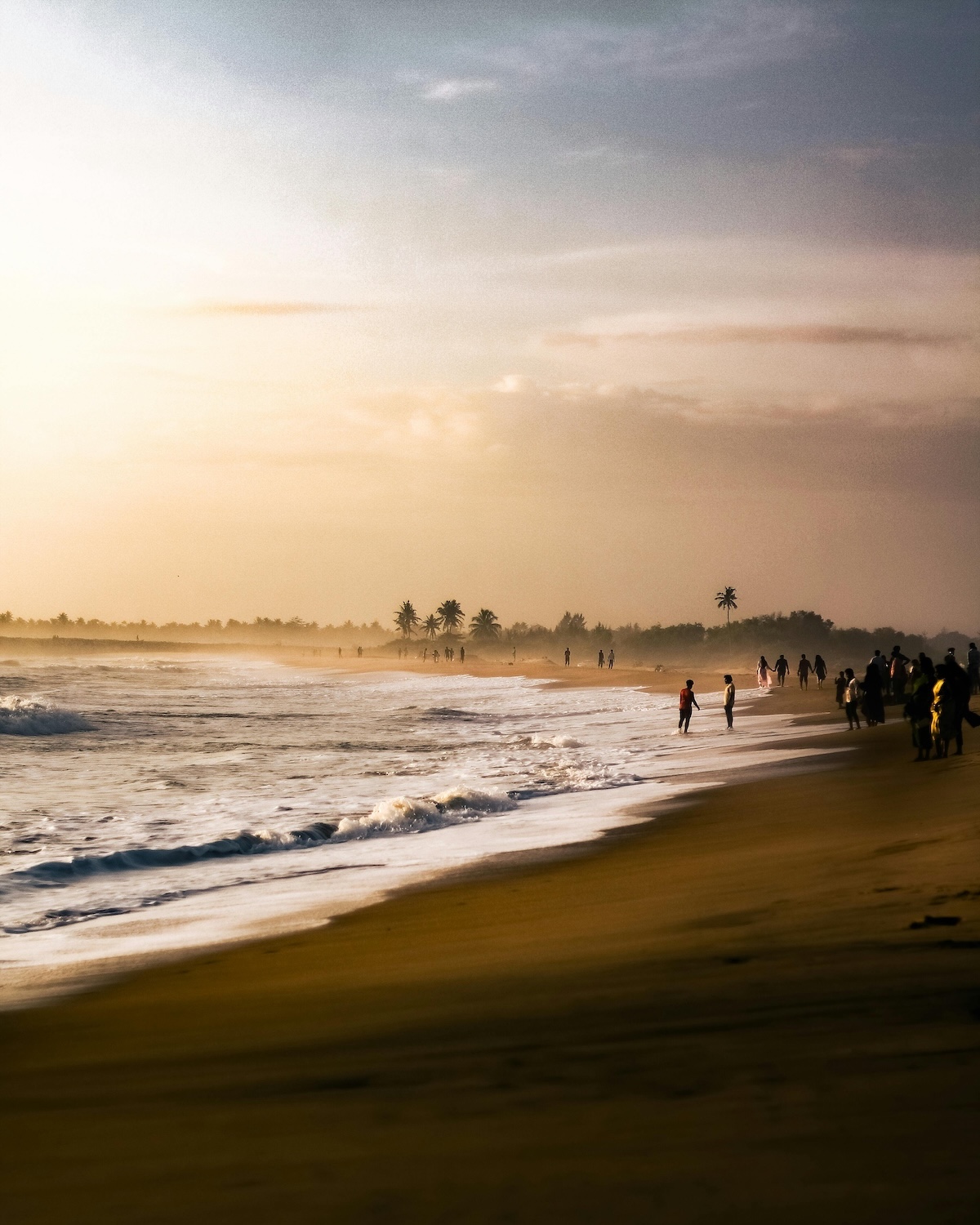 Figures walking the surf line at golden hour on a wide eastern beach, Sri Lanka | The Aficionados