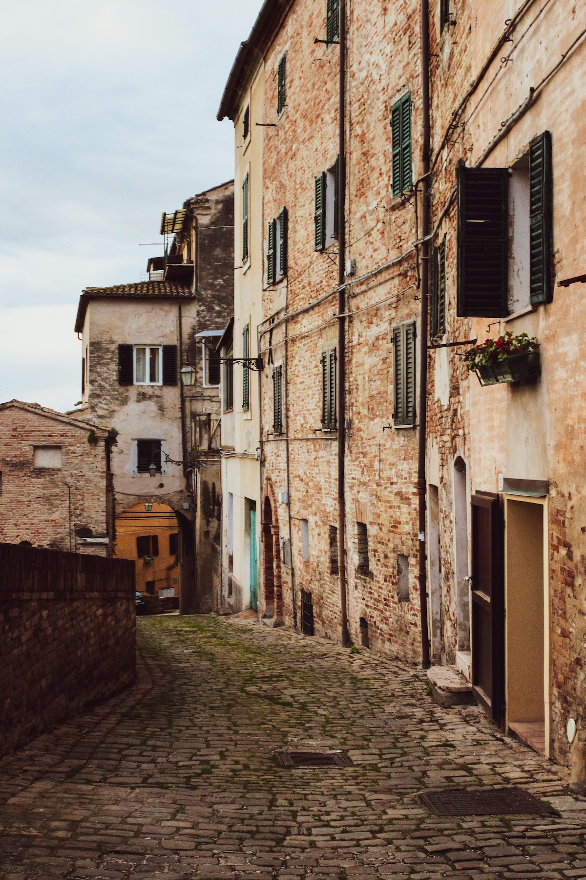 Golden wheat fields stretching toward the Apennine mountains under a dramatic sky, Le Marche Italy