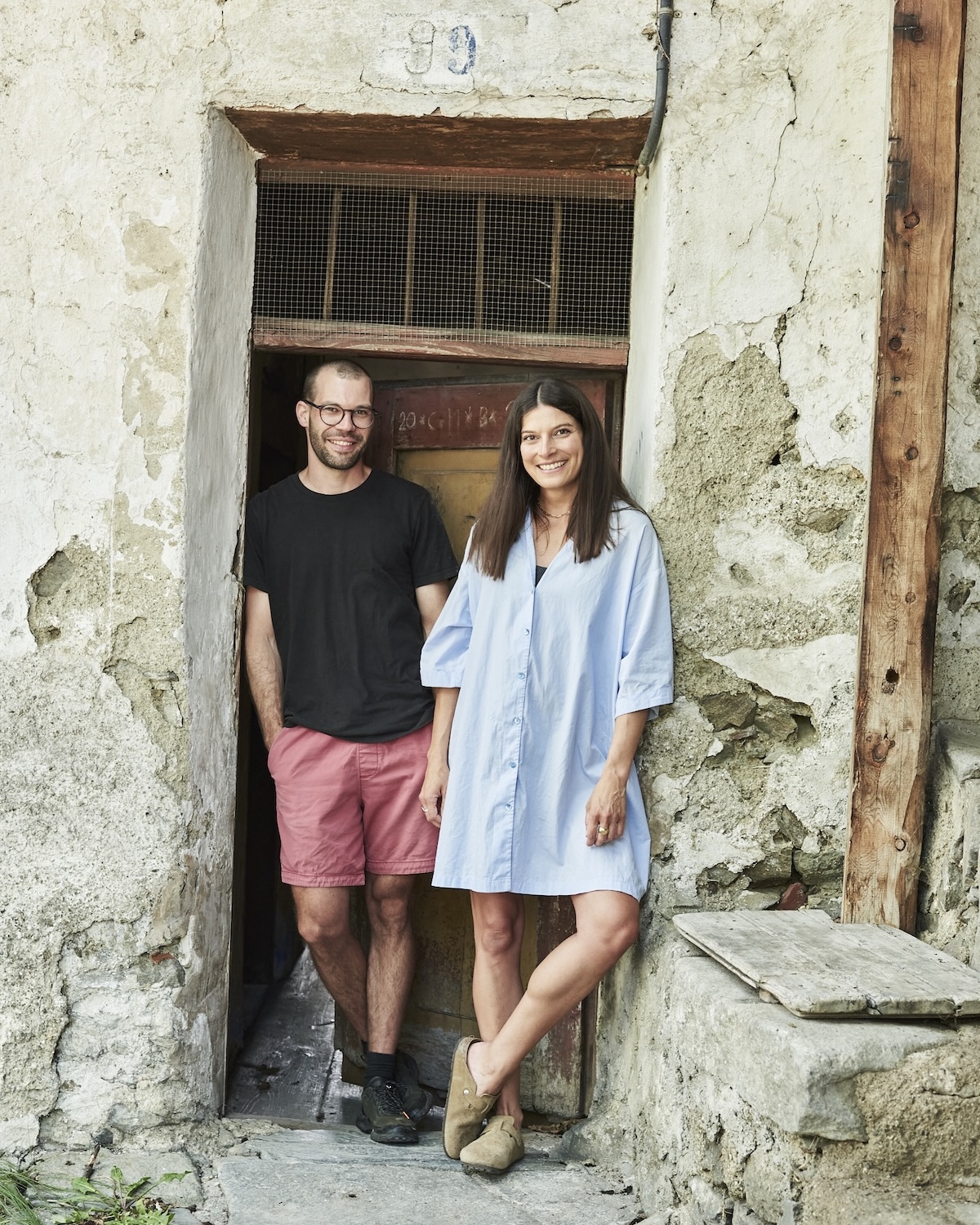 Carmen and Hannes Augschöll of Röck wines standing in a weathered stone doorway at their family estate in Villanders | The Aficionados