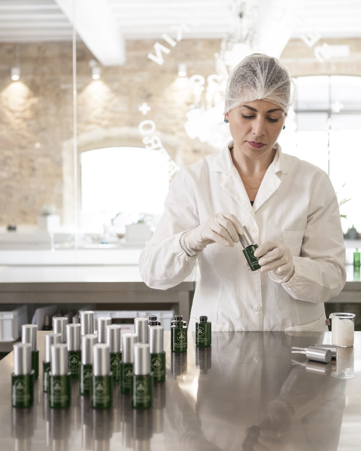 Seed to Skin Tuscany laboratory technician hand-finishing individual bottles of natural skincare on site in Chiusdino, Tuscany, artisan production, non-toxic luxury beauty made in Italy