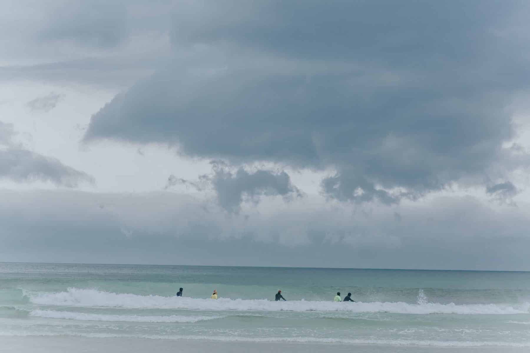 Surfers on Flakstad Beach Lofoten Norway | The Aficionados 