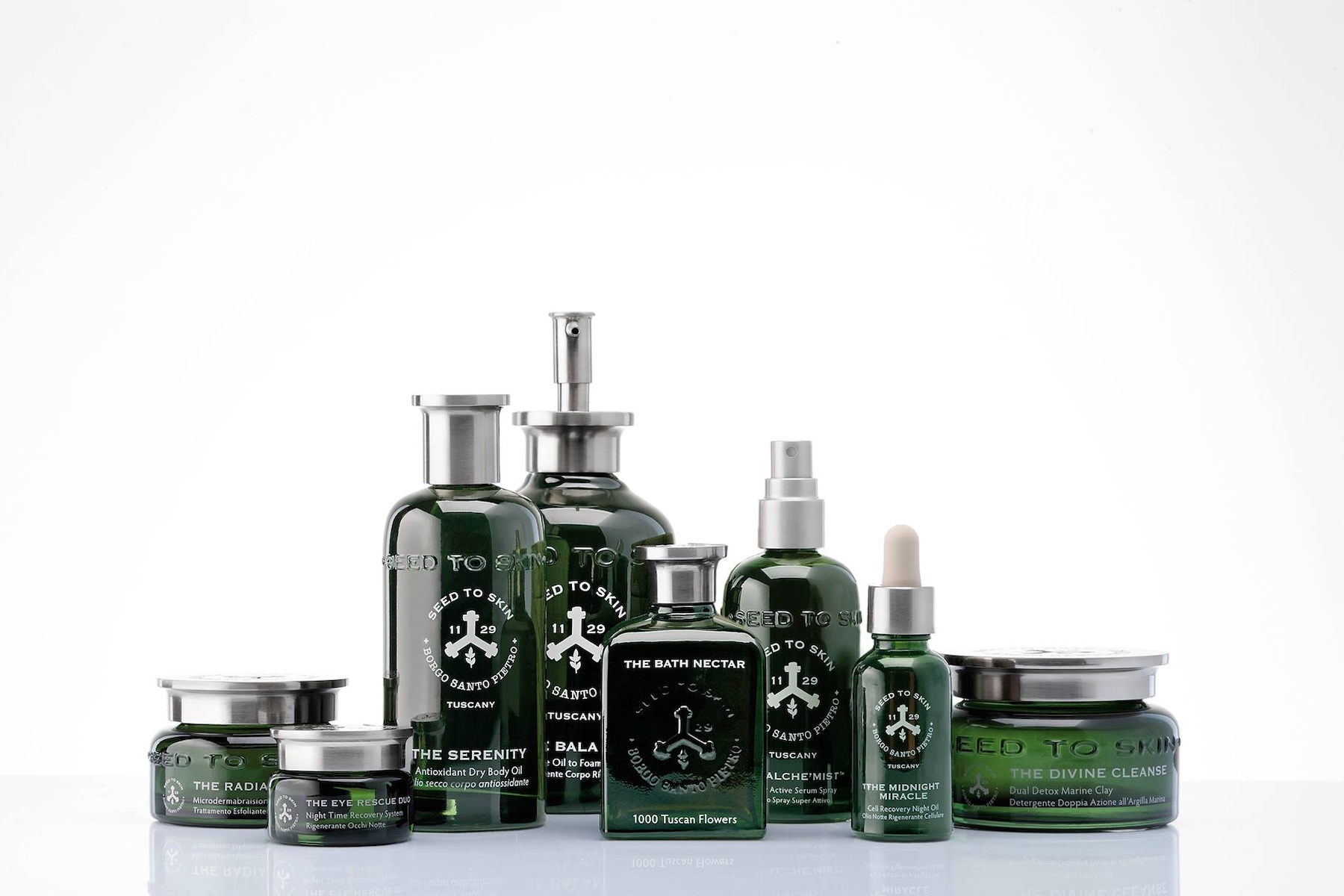 eed to Skin Tuscany full skincare collection in deep green glass bottles and jars with chrome lids, including The Divine Cleanse, The Midnight Miracle and The Alche'Mist, natural luxury skincare made in Tuscany, Italy