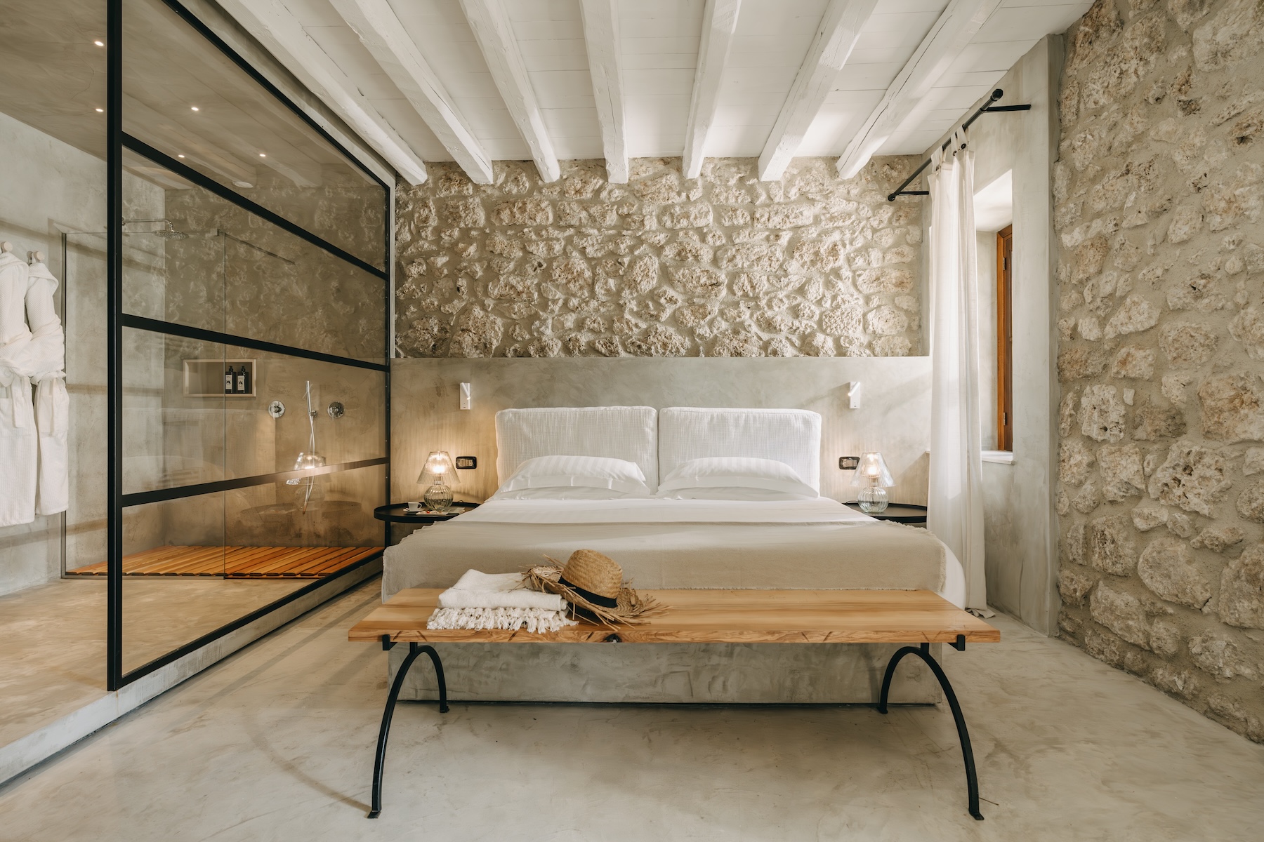 Suite at Susafa, conservative restoration of the original masseria stonework with whitewashed beams and a glass-walled wet room, sustainable country boutique hotel in the Madonie foothills, Sicily | The Aficionados.
