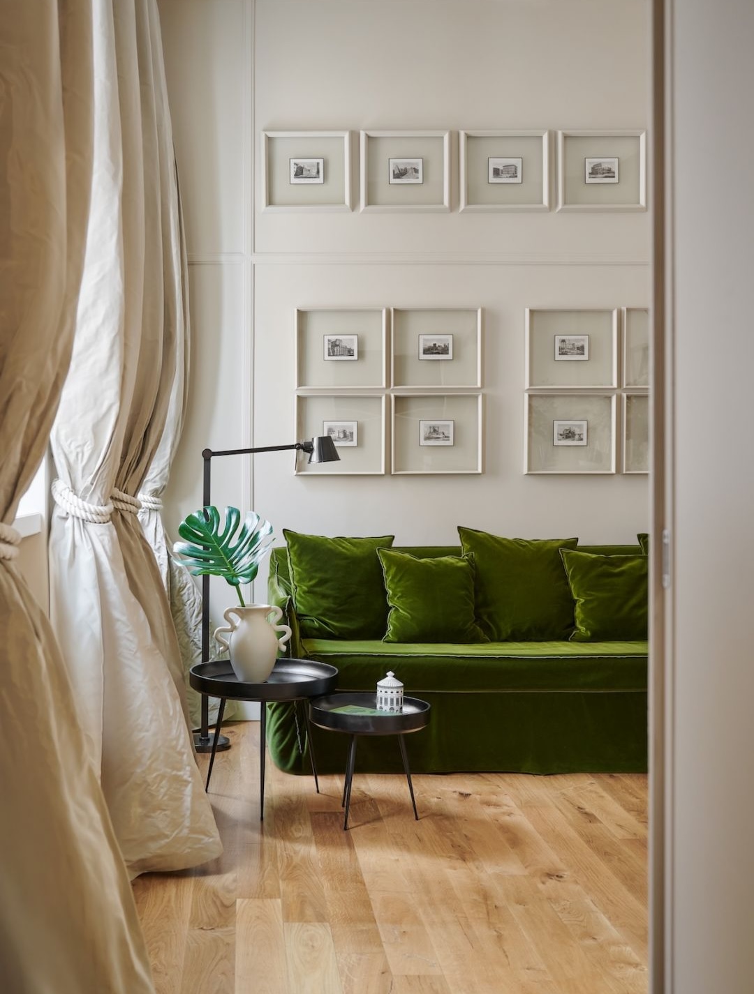 Green velvet sofa and grids of framed etchings in a cream-panelled luxury suite near the Piazza di Spagna, Rome