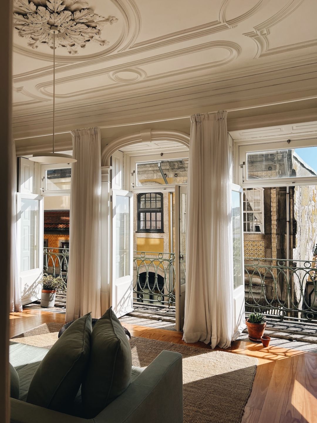 B28, Porto: restored townhouse salon with acanthus plasterwork ceiling and French windows onto azulejo façades, architecture by José Bernardo Távora.