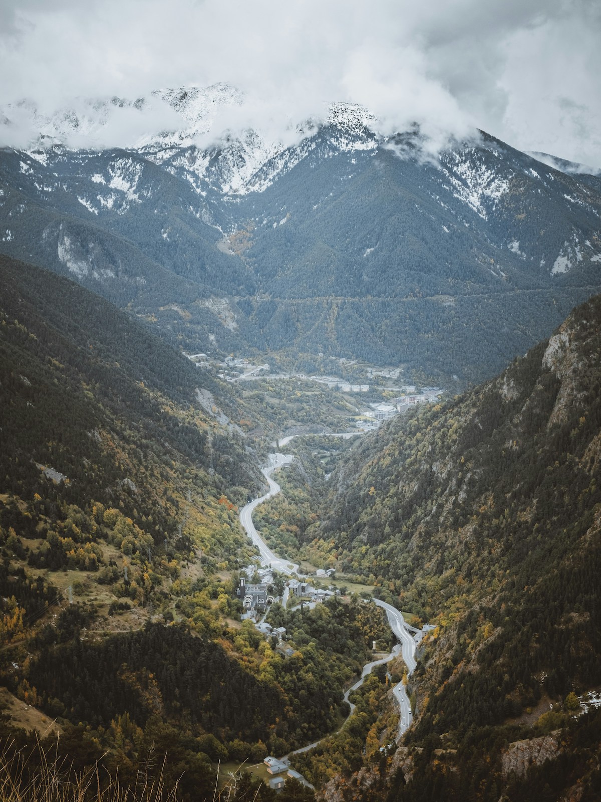 First snow on the high peaks above larch and pine slopes in autumn, Andorra