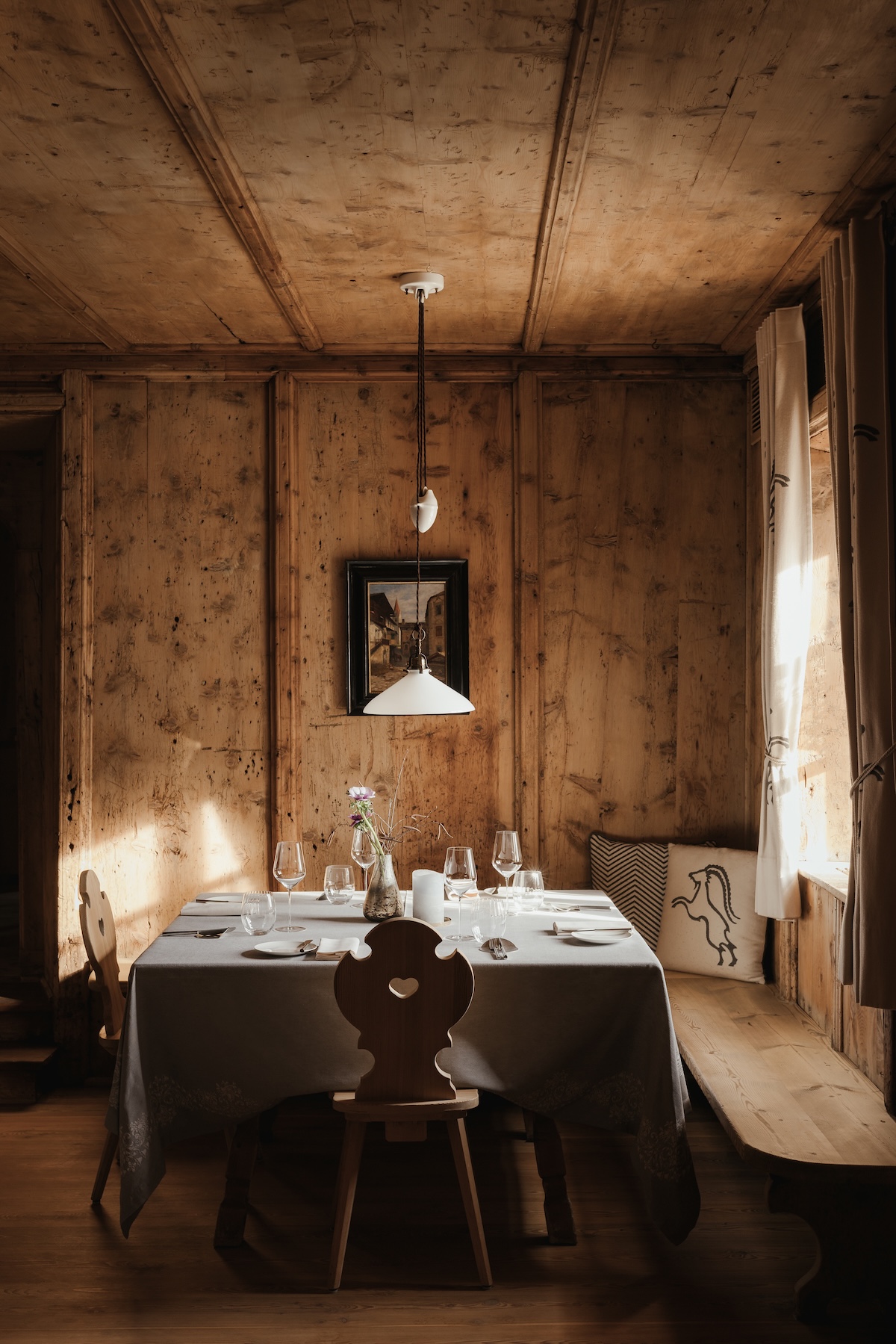Wood-panelled dining room table set for fine dining at La Lumosa, Ansitz Steinbock, Villandro