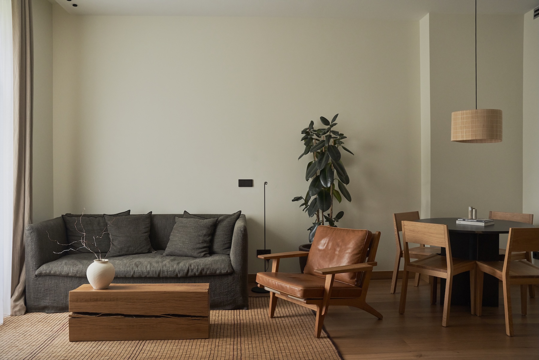 Living area at Hotel Arbaso with a linen sofa, tan leather armchair and woven pendant light | The Aficionados