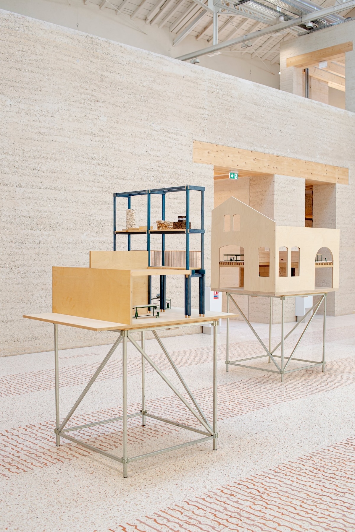 Architectural models on slender metal trestle tables set against rammed earth walls at Atelier LUMA, Arles | The Aficionados