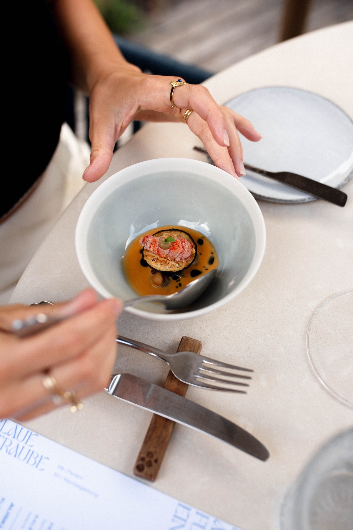 An opening course arriving in a hand-thrown stoneware bowl on cream linen at Christoph Huber's Blaue Traube, Lagundo | TheAficionados.com