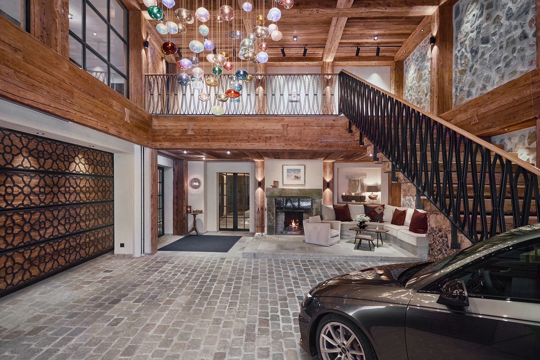 Worlds only luc=xury car drive through reception | Reclaimed-timber and stone entrance hall of BelArosa Chalet with a glass-bubble chandelier and fireside lounge | The Aficionados