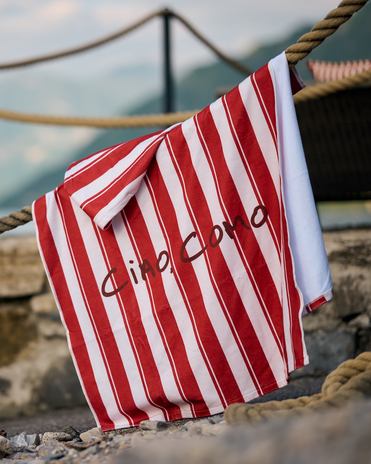 GUESS Ciao Como striped beach towel detail in red-and-cream awning stripe, Filario Hotel summer lido, Lezzeno shoreline, Italian design collaboration | TheAficionados.com