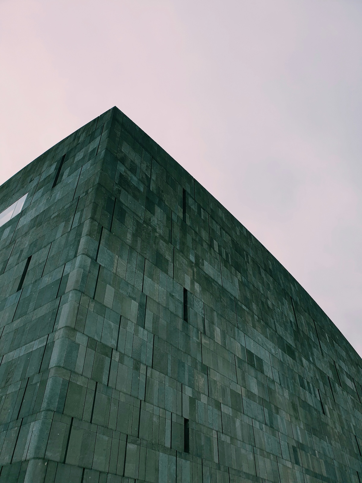 The dark basalt-clad corner of the mumok museum rising against a pale sky in Vienna's MuseumsQuartier