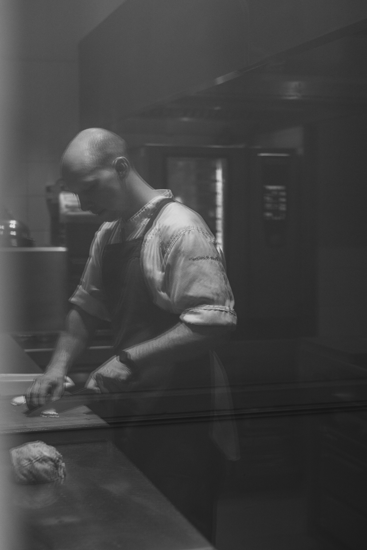 Chef Pieter Starmans at work in the kitchen, shot through glass, at August, Antwerp | The Aficionados