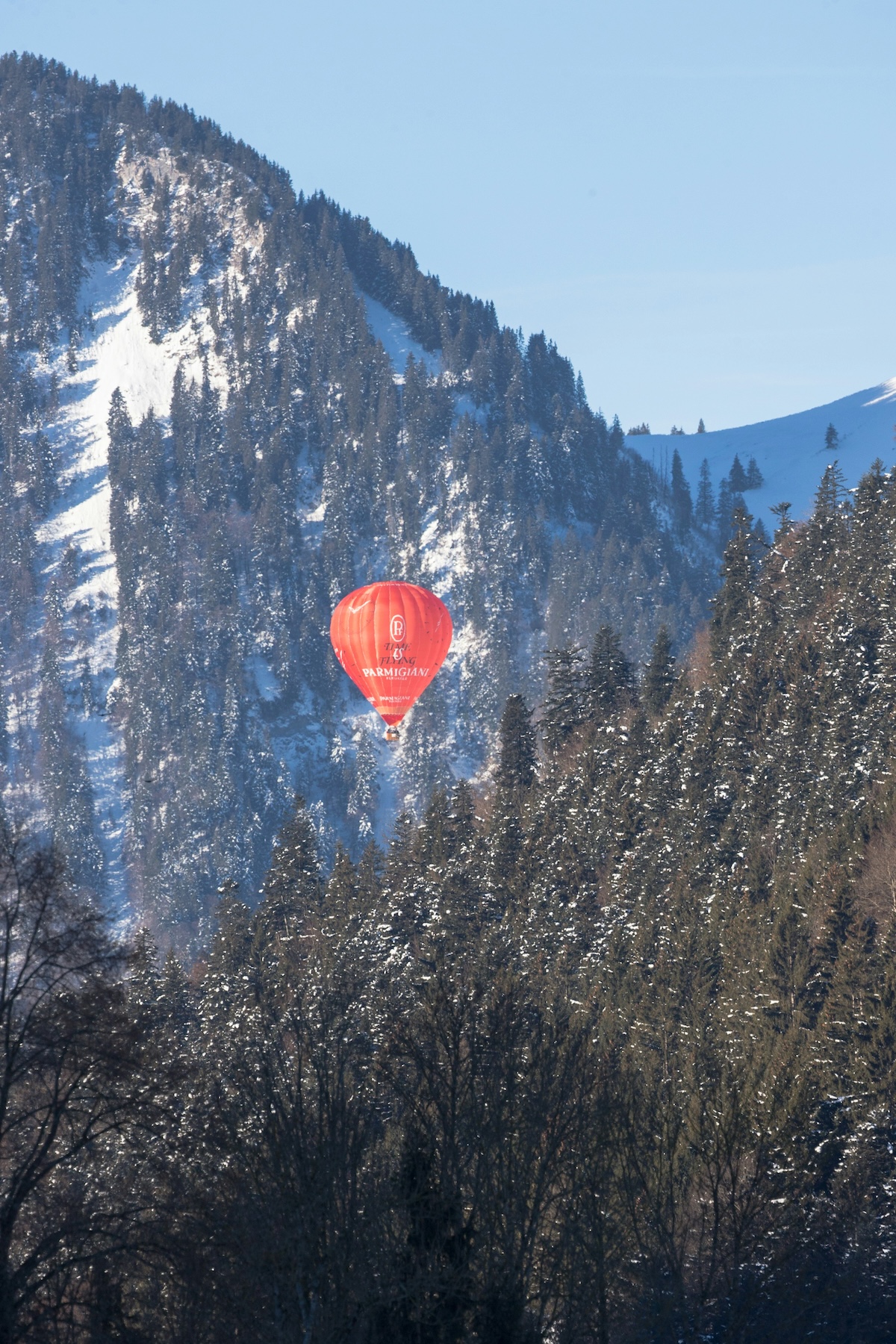 A colourful photo of Switzerland's famous hot air balloon festival, blue sky and balloons in it