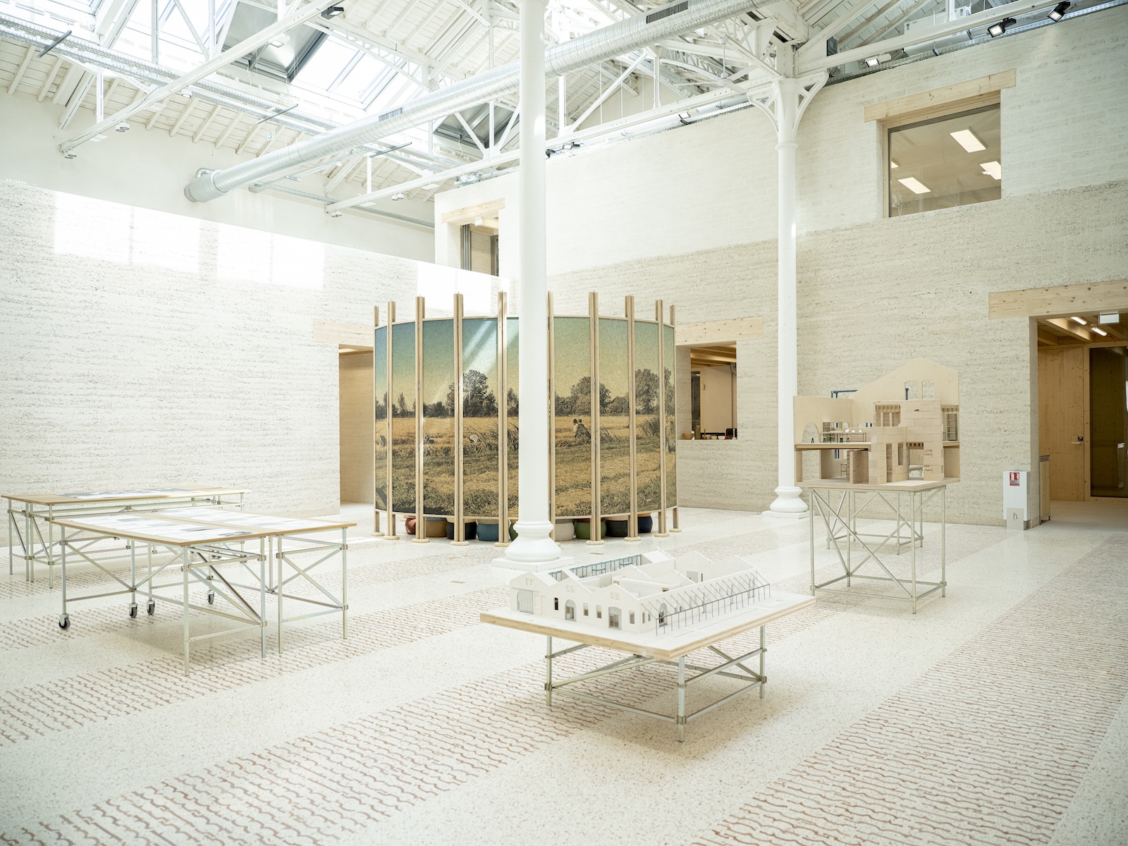 The light-filled interior of Le Magasin Électrique at Atelier LUMA, with terrazzo flooring, rammed earth walls and architectural models on display | The Aficionados