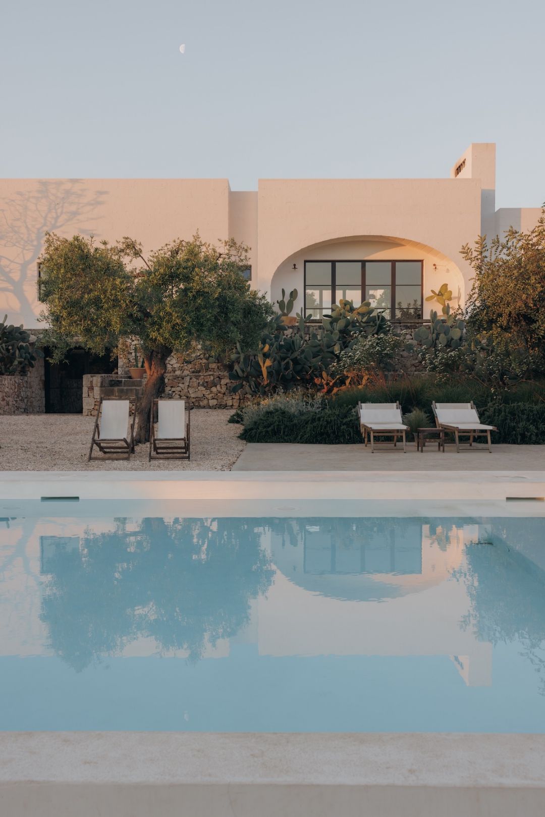 MOROSETA LIVING Design Villas| Whitewashed Puglian masseria with a still pool, olive tree and cactus garden under a rising moon