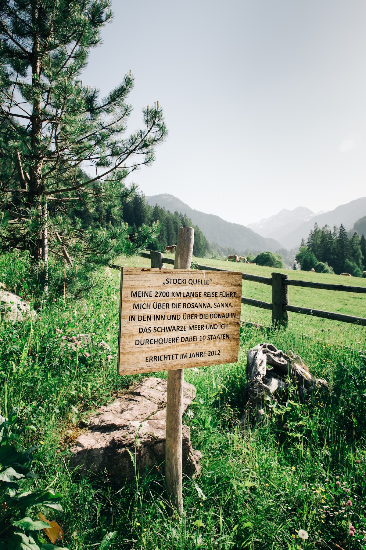 The Stocki Quelle spring marker in a grazing meadow near St. Anton, where mountain water begins its journey along the Rosanna | The Aficionados