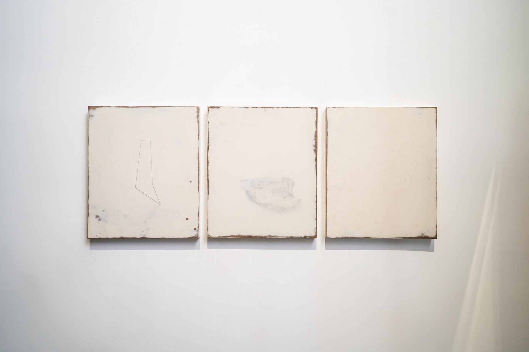 Minimalist triptych of three cream panels with weathered rust-toned edges, part of Peter Harris's contemporary art collection at Doornberg, the Dutch colonial villa above Galle, Sri Lanka | The Aficionados.