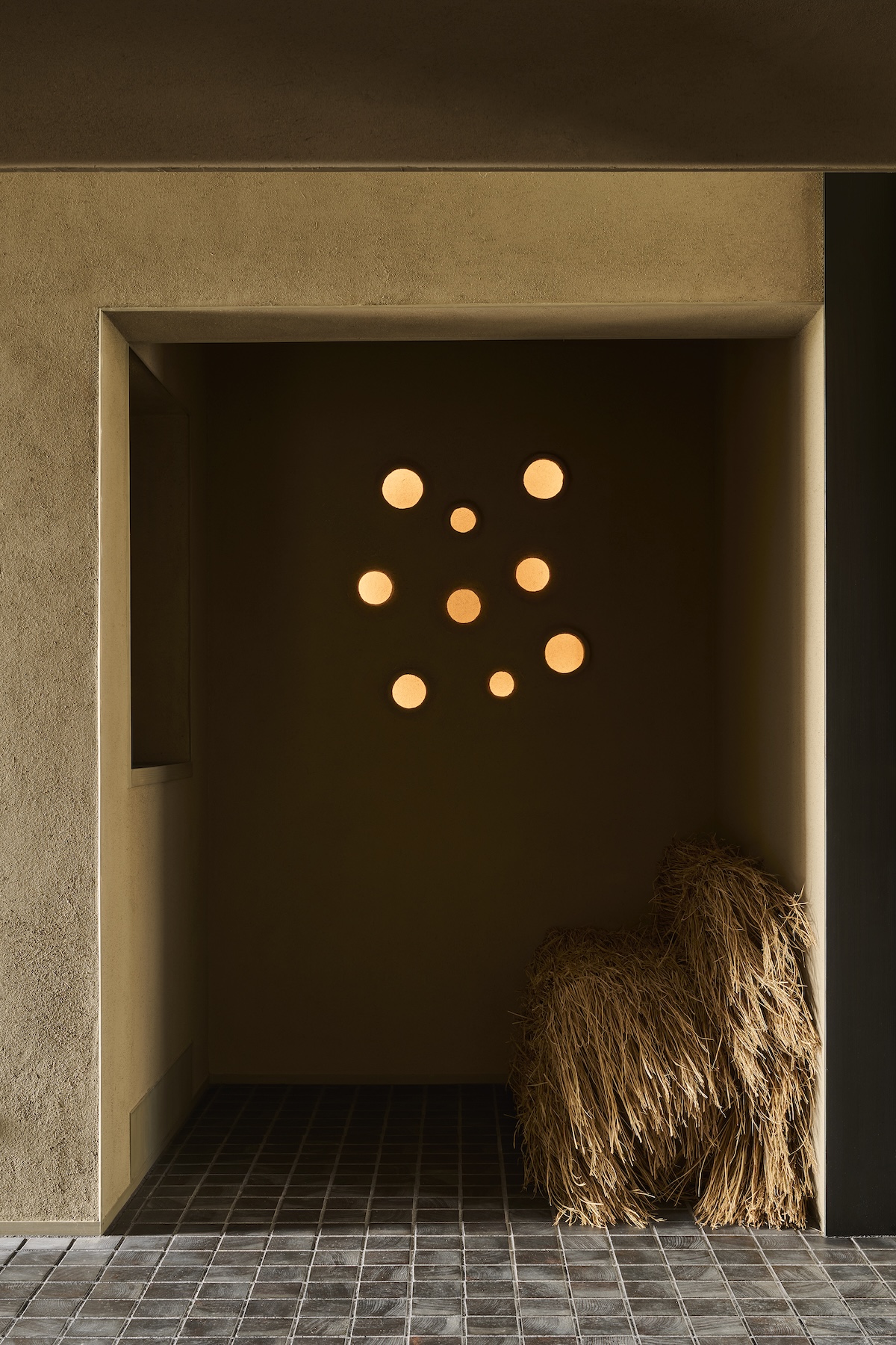 Plaster-embedded constellation lighting and rice straw sculpture in an earthen-walled alcove at Né, Shibata, Niigata, Japan | The Aficionados.