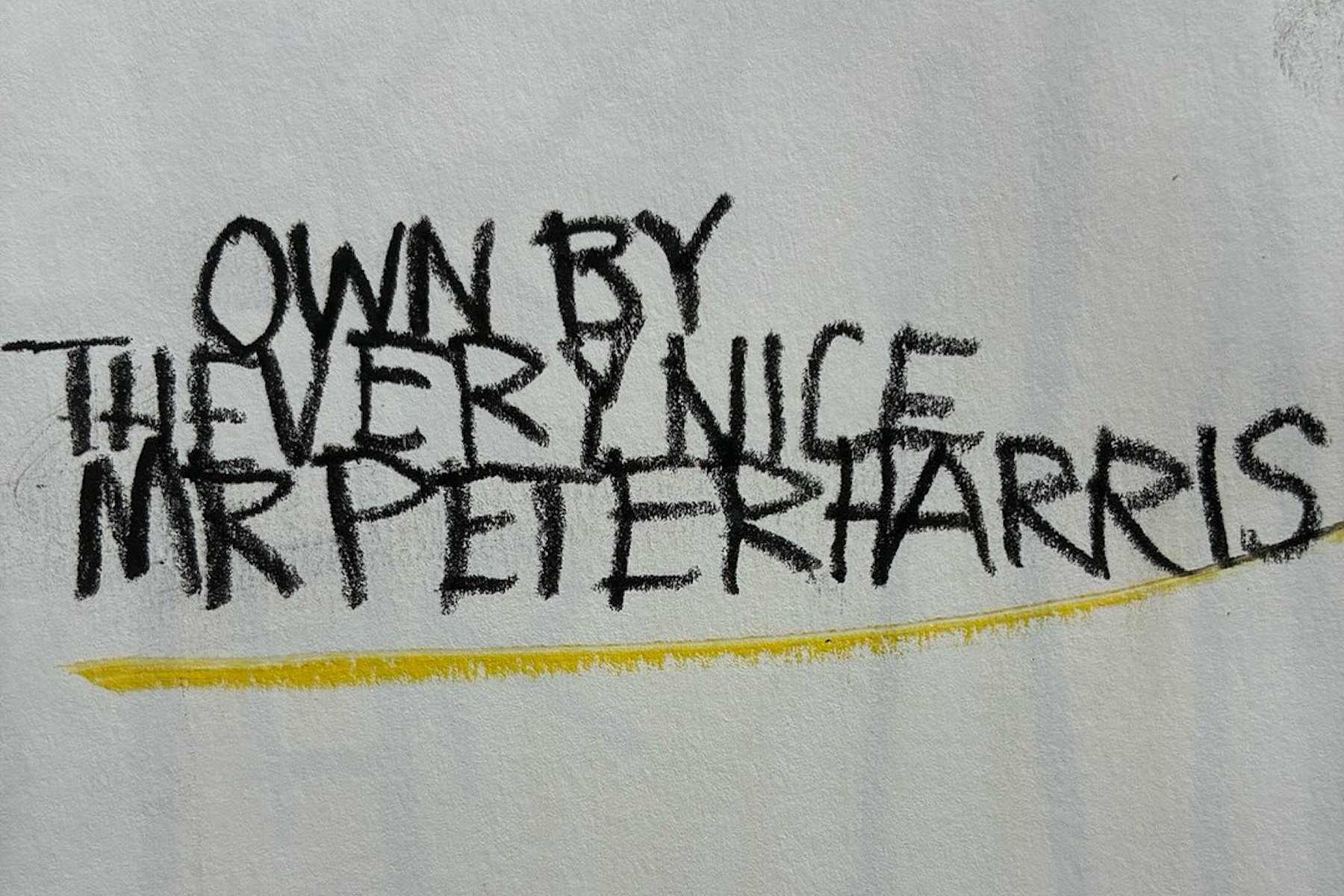 Hand-scrawled charcoal lettering on white, reading 