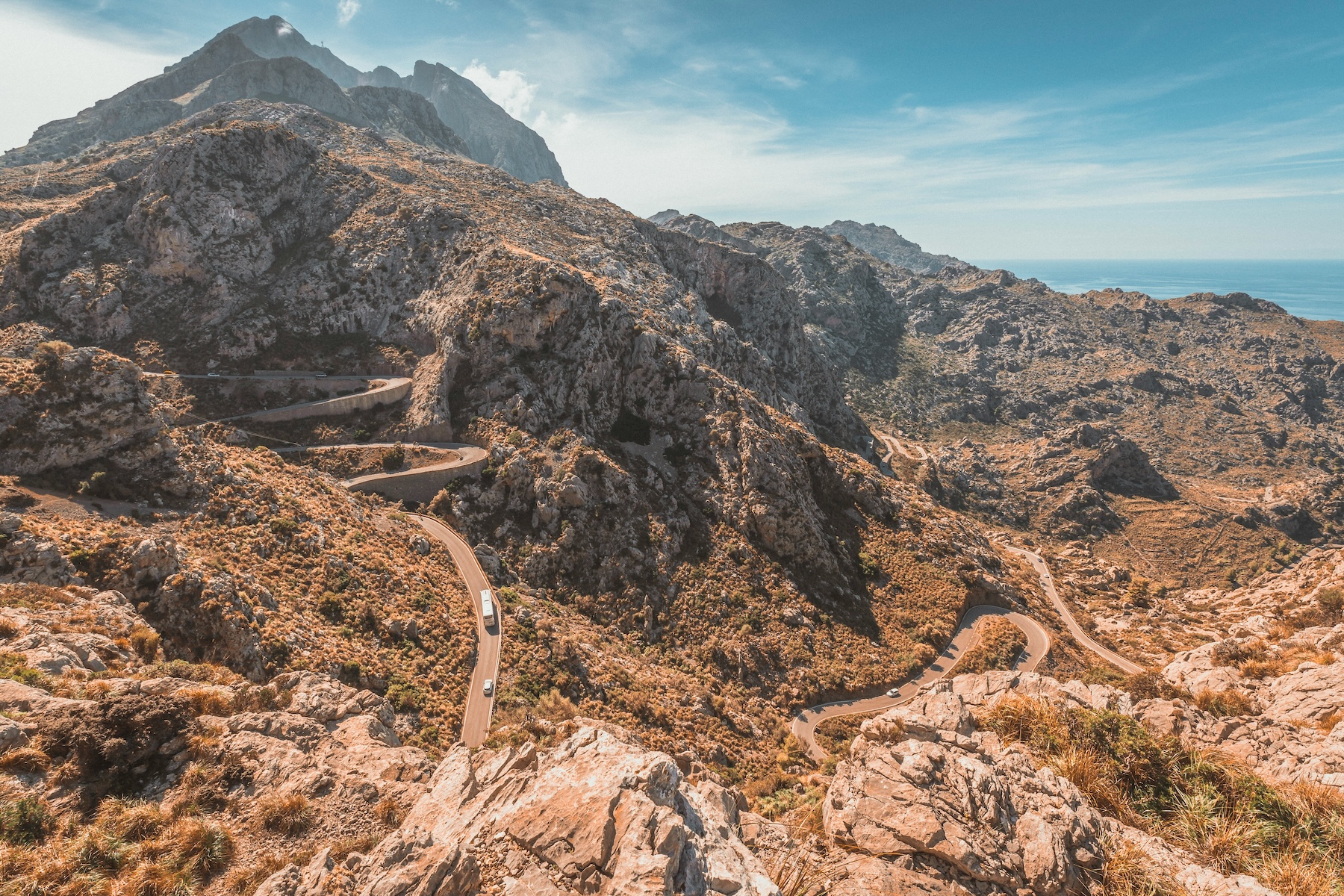 A hairpin mountain road winding down through the Serra de Tramuntana towards the sea, Mallorca | The Aficionados