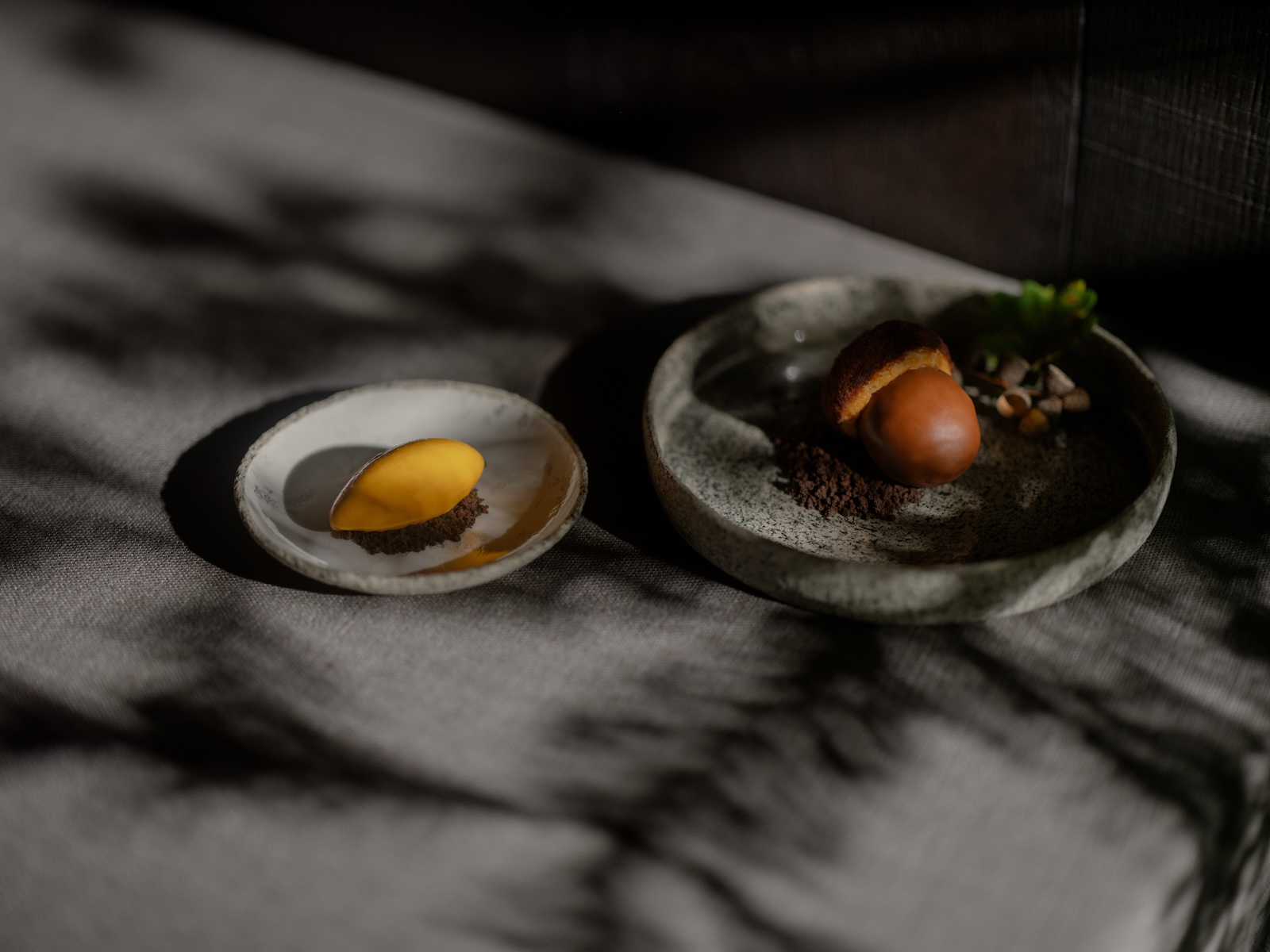 Chef Michael Helfrich in silva-branded blacks against a dark leather-tiled wall, the Noma-trained head chef of silva at Naturhotel Forsthofgut, Leogang, Austria | The Aficionados.