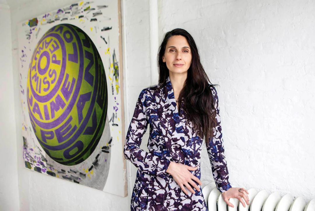 Red Flower founder Yael Alkalay beside a bold contemporary artwork at her New York studio, creator of all-natural aromatherapeutic botanical skincare made in Tribeca | The Aficionados