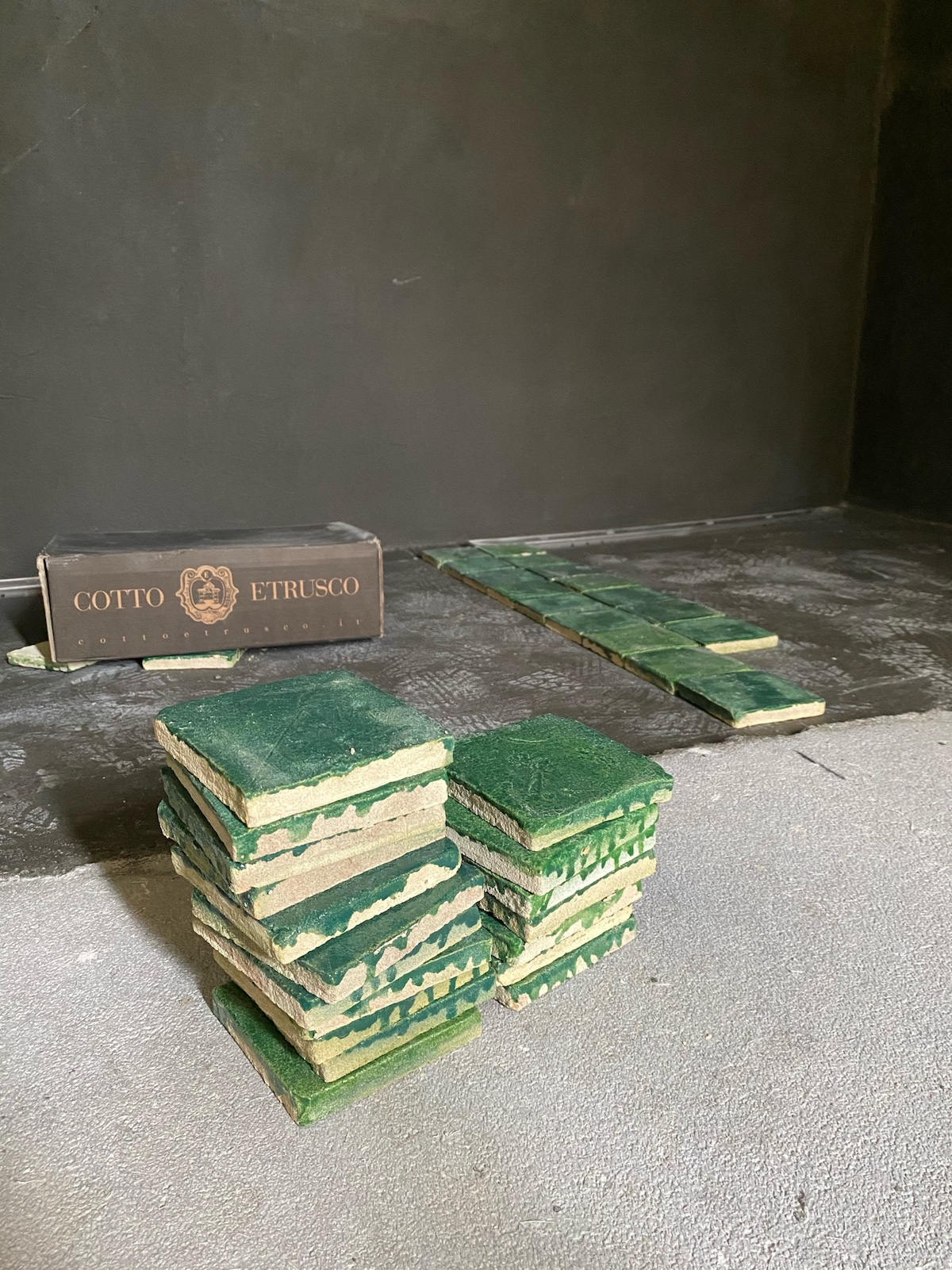Handmade ceramic Tiles in glazed green stacked on a table, square imperfect | Vocabolo Moscatelli: A 12th-Century Monastery Reborn as a Boutique Design Hotel in Umbria