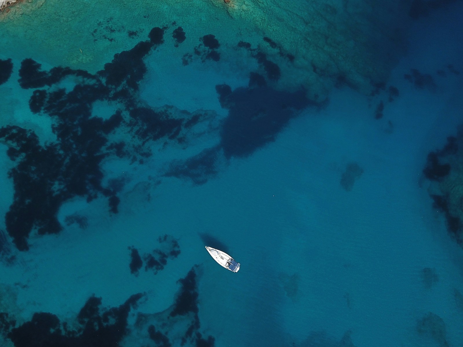 A solo white Yacht boat in the Aegean blue waters - coral visable |Günlüklü Bay: Türkiye’s Hidden Forested Cove of Natural Luxury